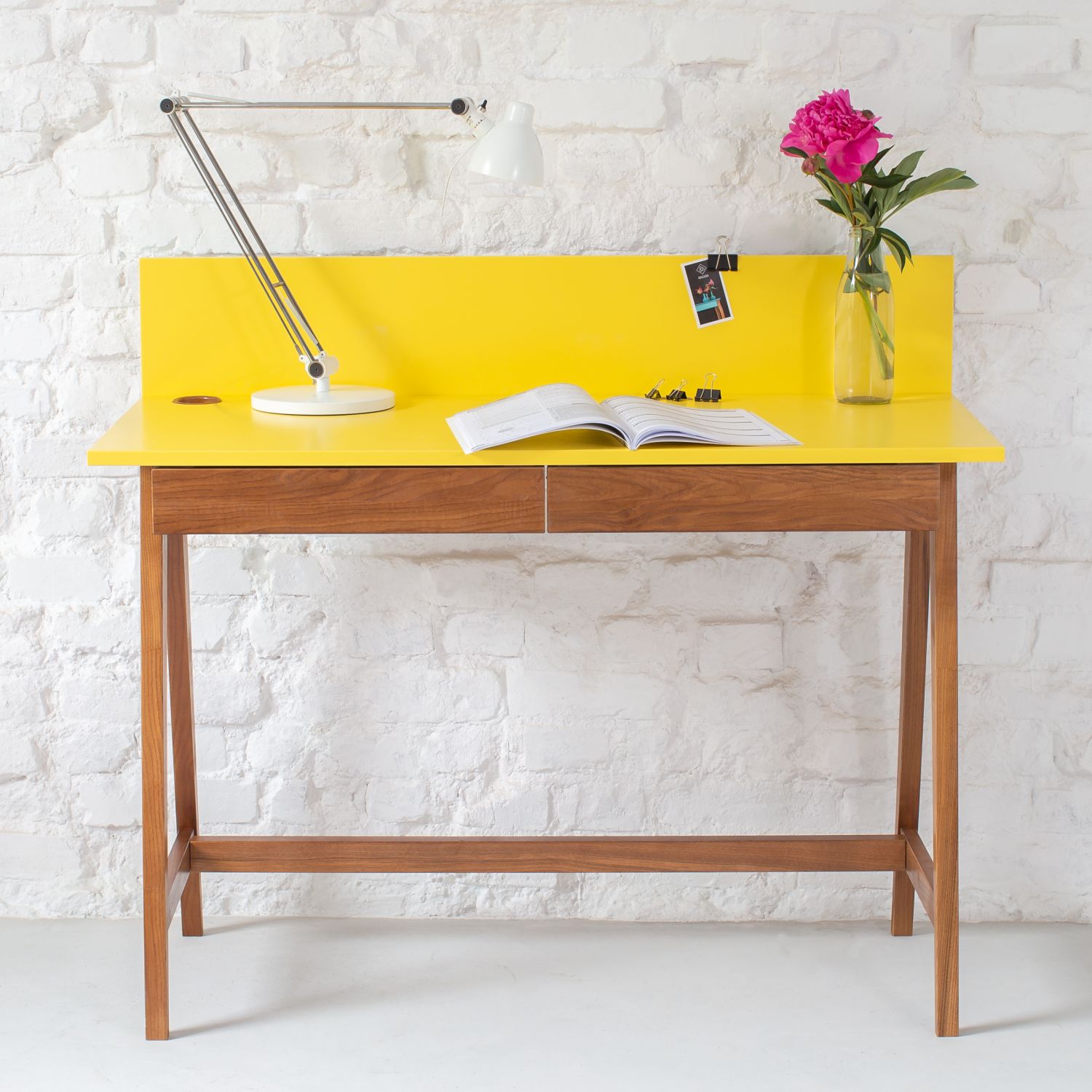 Minimalist wooden desk setup with framed art and plant